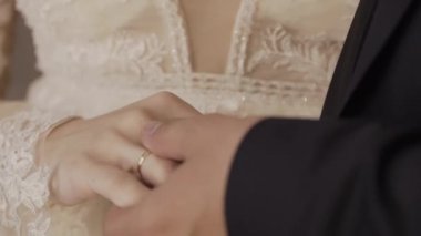 Yeni evli çift elele. Düğün çiçekleri. Yakın çekim.
