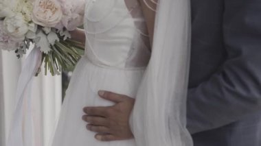 Evlen benimle bugün ve her gün. Yeni evli çift tutuşup, ağır çekimde atış.
