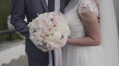 Evlen benimle bugün ve her gün. Yeni evli çift tutuşup, ağır çekimde atış.