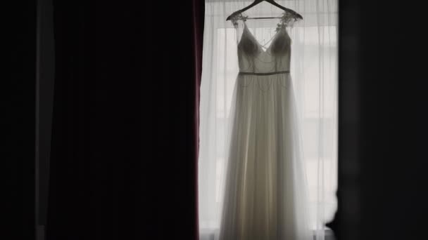 Beautiful wedding dress hanging in a large chandelier. — Stock Video