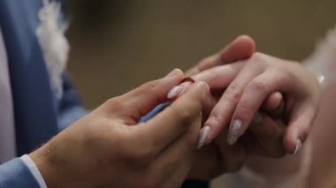 Çok güzel yeni evliler birbirlerine yüzük koymak.