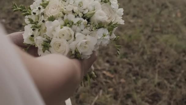 아름 다운 흰색 웨딩 꽃 부케를 들고 레이스 드레스 신부. — 비디오