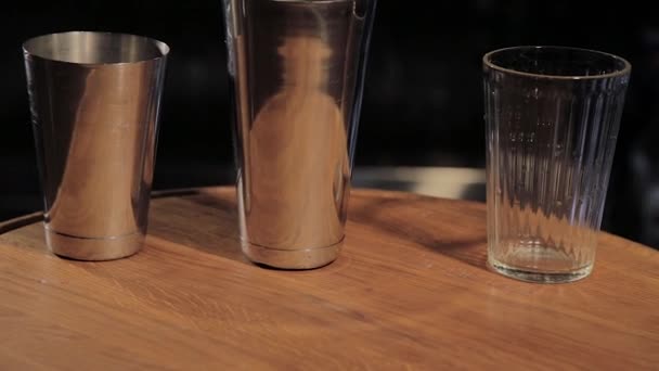 鸡尾酒摇摆机和烧杯准备饮料在酒吧柜台在酒吧关闭关闭。夜总会的鸡尾酒吧用具、摇摆机和烧杯. — 图库视频影像