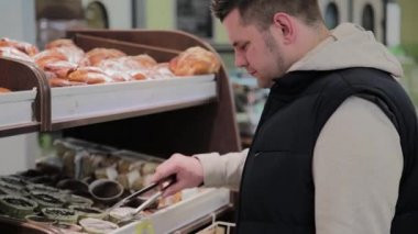 bir süpermarket adam kendi için hamur işleri seçer.
