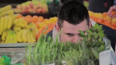 Süpermarkette şişman adam kendi için meyve seçer.