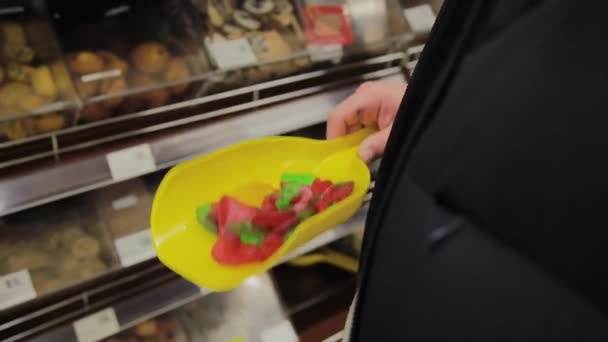 Fat Man in de supermarkt kiest voor snoepjes voor zichzelf. — Stockvideo