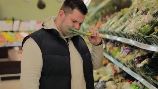 Hombre gordo en el supermercado elige fruta para sí mismo . — Vídeo de stock