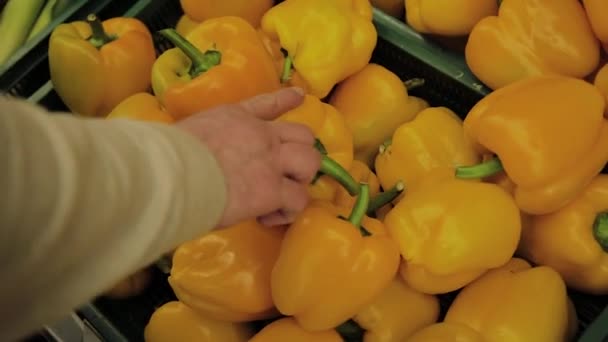 Fat Man in de supermarkt kiest voor zichzelf fruit. — Stockvideo