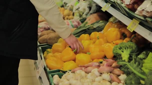 Fat Man in de supermarkt kiest voor zichzelf fruit. — Stockvideo