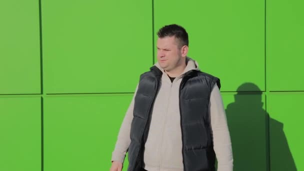 Hombre gordo posando contra una pared verde cerca de la tienda . — Vídeo de stock