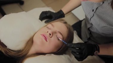 Bir güzellik salonunda çok güzel bir kız bir laminasyon kirpikleri yok. Güzellik prosedür kirpik parçalanma gerçekleştirir.