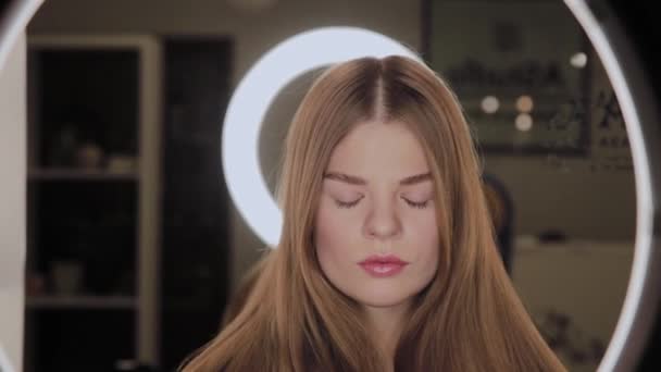Retrato de una niña con un reflejo de la luz led anular en los ojos . — Vídeos de Stock