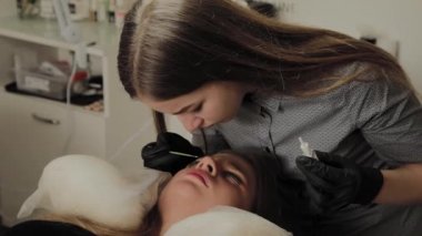 Bir güzellik salonunda çok güzel bir kız bir laminasyon kirpikleri yok. Güzellik prosedür kirpik parçalanma gerçekleştirir.