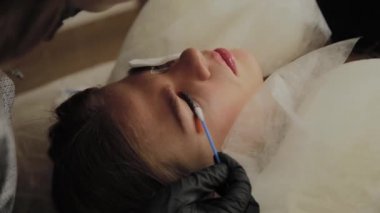 Bir güzellik salonunda çok güzel bir kız bir laminasyon kirpikleri yok. Güzellik prosedür kirpik parçalanma gerçekleştirir.