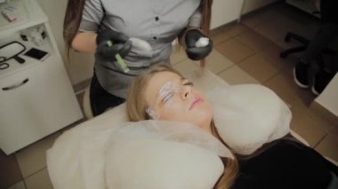 Bir güzellik salonunda çok güzel bir kız bir laminasyon kirpikleri yok. Güzellik prosedür kirpik parçalanma gerçekleştirir.