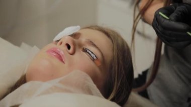 Bir güzellik salonunda çok güzel bir kız bir laminasyon kirpikleri yok. Güzellik prosedür kirpik parçalanma gerçekleştirir.