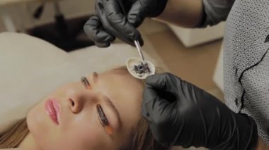 Bir güzellik salonunda çok güzel bir kız bir laminasyon kirpikleri yok. Kuru kirpik üzerinde tutkal bekliyor