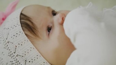 Güzel küçük kız beyaz yatakta yatıyor.