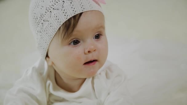 Beautiful little girl is lying on the white bed. — Stock Video