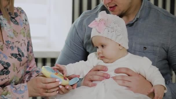 Joyeux famille jouant avec leur petite fille sur un lit blanc . — Video