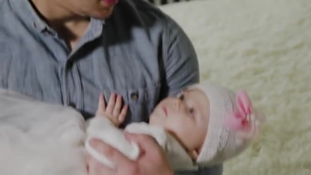 Giovane papà culla una bambina su un letto . — Video Stock
