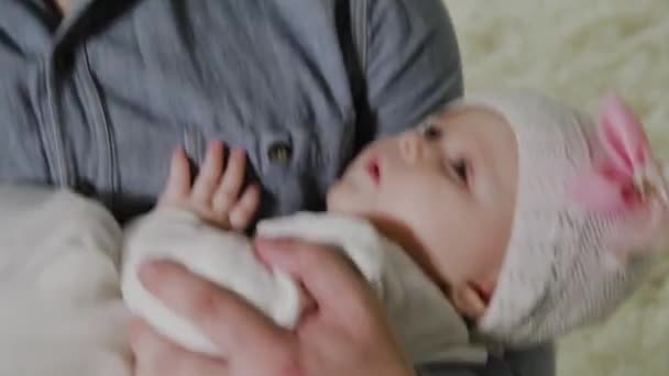 Молодой папа укладывает маленькую девочку на кровать . — стоковое видео