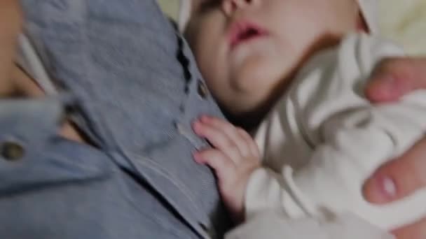 若いお父さんは、ベッドの上に小さな女の子をクレードル. — ストック動画