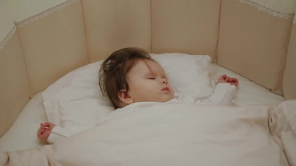 Vacker liten flicka som sover i sin barnsäng. — Stockvideo
