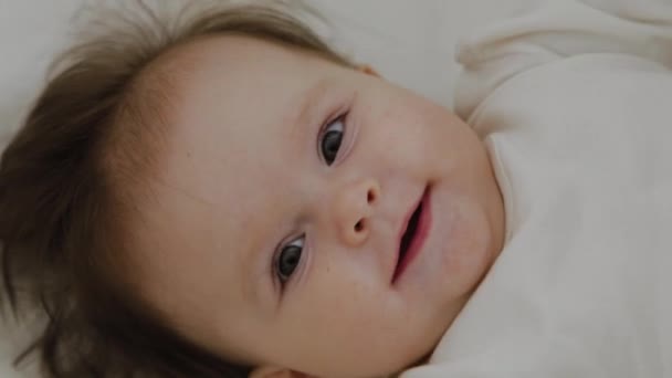 Beautiful little girl woke up and smiles at the camera — Stock Video