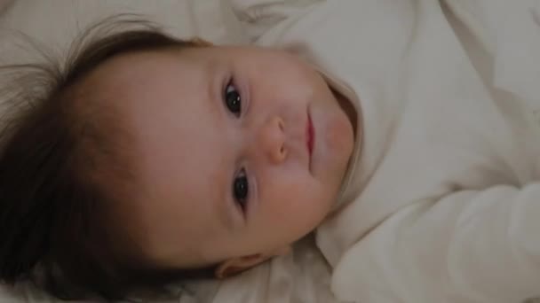 Vacker liten flicka vaknade och ler på kameran — Stockvideo