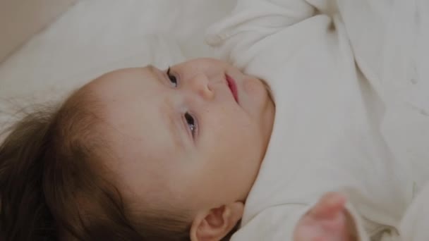 Mooie kleine meisje wakker en glimlacht naar de camera — Stockvideo