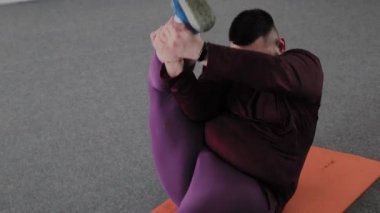 Şişman adam Fitness için mat üzerinde germe yapıyor.