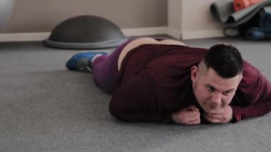 egzersiz sonrası spor salonunda yerde yatan şişman adam.