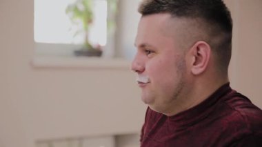 Bir adam sabahları kahvaltıda protein sağlık içeceği içiyor..