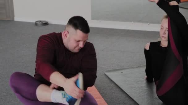 Kövér nő és az ember nyúlik a fitness szőnyeg. — Stock videók