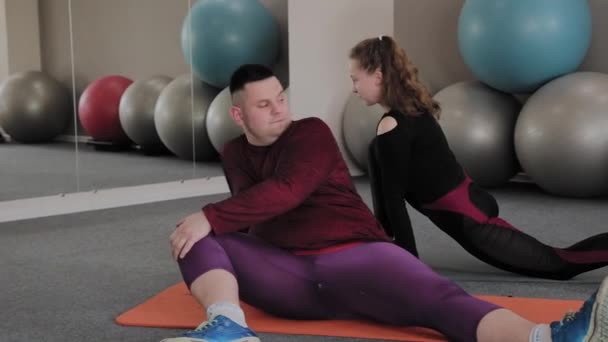 在健身垫上伸展运动的胖女人和男人. — 图库视频影像