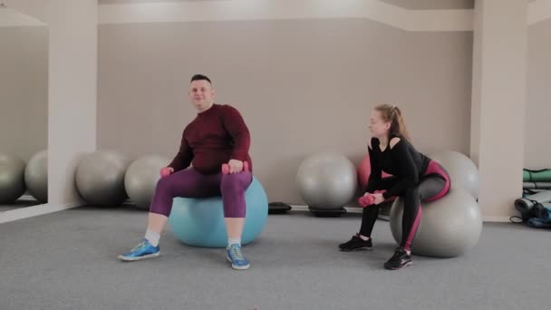 Pareja grasa positiva haciendo ejercicio con pelotas de fitness — Vídeos de Stock