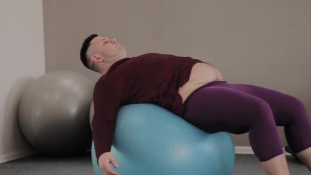 Vidám kövér ember vonatok a fitness labda. — Stock videók