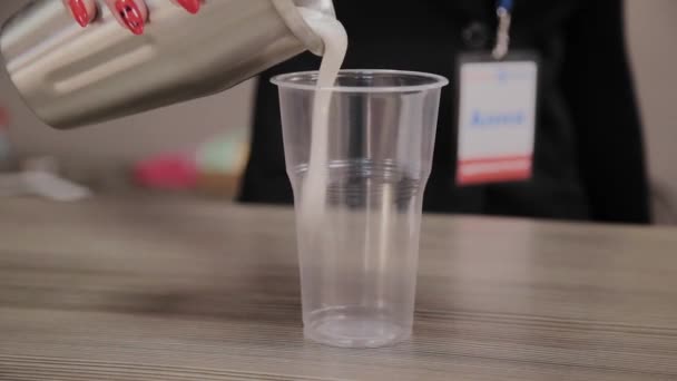 Πρωτεΐνη μιλκσέικ με γάλα χύνεται σε ένα πλαστικό Κύπελλο. — Αρχείο Βίντεο