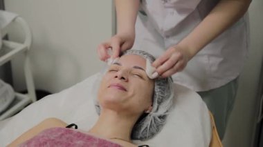 Bir kadın güzellik salonunda özel mendiller ile temizlenir.