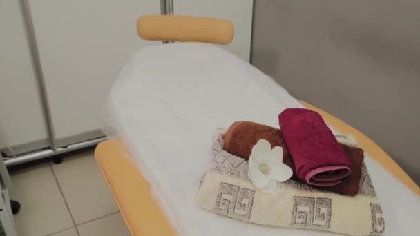 Lounger för thailändsk massage med hand dukar, kuddar och blommor i tomma rum. — Stockvideo