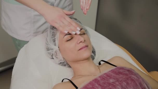 Mujer haciendo masaje facial en el salón de spa . — Vídeos de Stock
