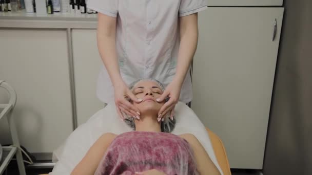 Femme faisant un massage facial au salon de spa . — Video