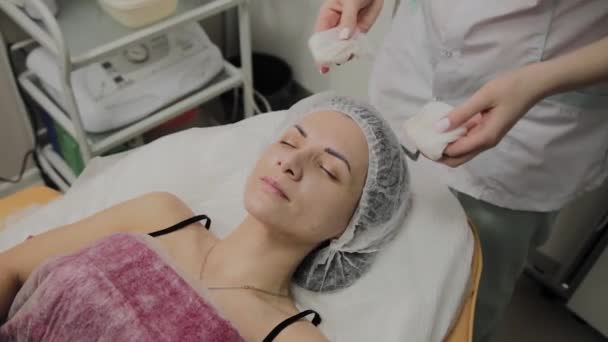 Een vrouw wordt schoongemaakt met speciale doekjes in de schoonheidssalon. — Stockvideo