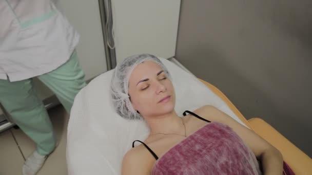 Bella giovane donna in accappatoio sdraiato e in attesa procedura di cura del viso al salone di lusso spa — Video Stock