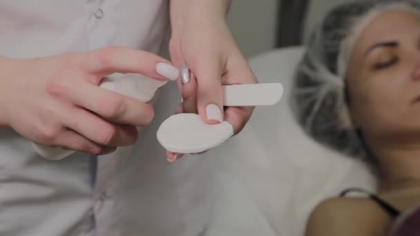 Die Kosmetikerin trägt vor dem Eingriff Flüssigkeit auf ein Wattepad auf. Kosmetische Innovationen. — Stockvideo