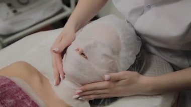 Bir kadın güzellik salonunda özel mendiller ile temizlenir.