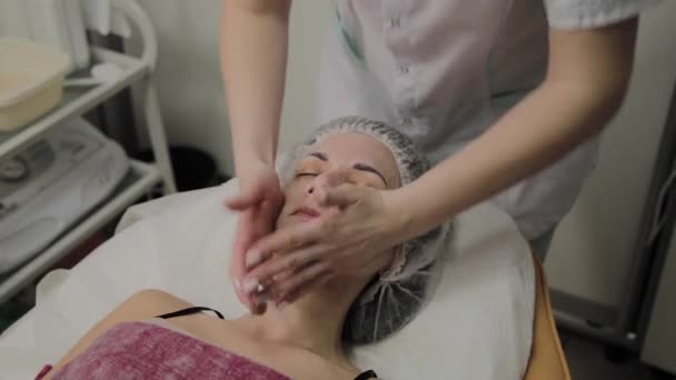 Mujer haciendo masaje facial en el salón de spa . — Vídeos de Stock