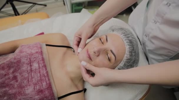 Женщина делает массаж лица в спа-салоне . — стоковое видео