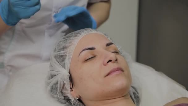 Un cosmetólogo profesional hace que una mujer limpie la cara al vacío en un salón de belleza. Innovaciones cosmetológicas . — Vídeos de Stock
